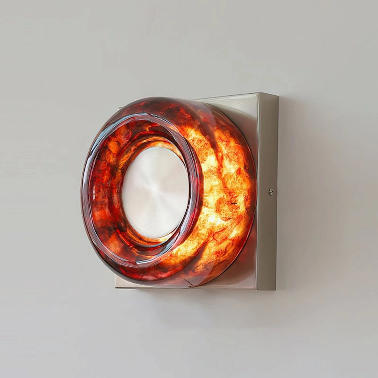 Red circular wall sconce mounted beside bedroom mirror in contemporary minimalist design