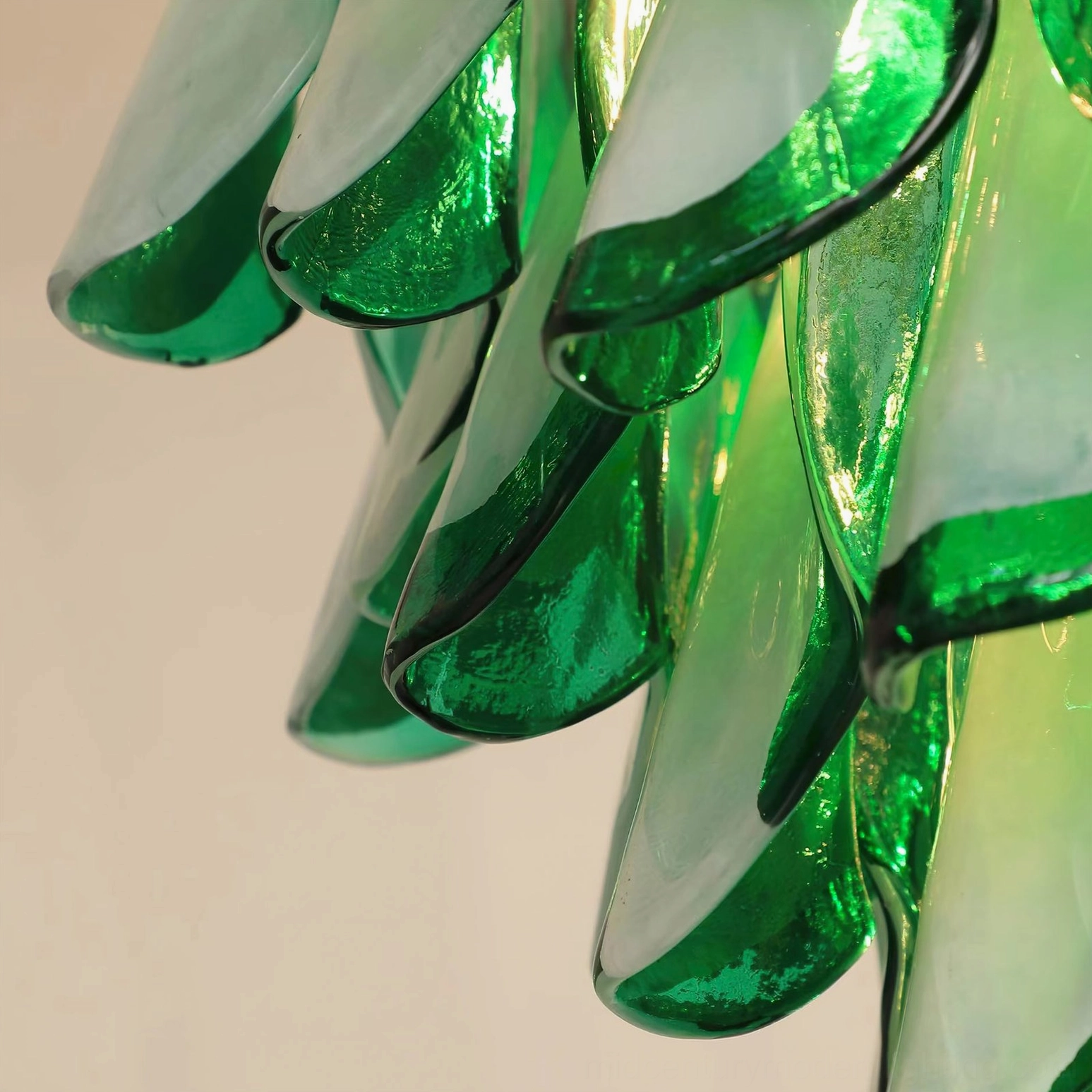Low-angle close-up of reflective glass petals showing green-white color blend and glossy finish artistry