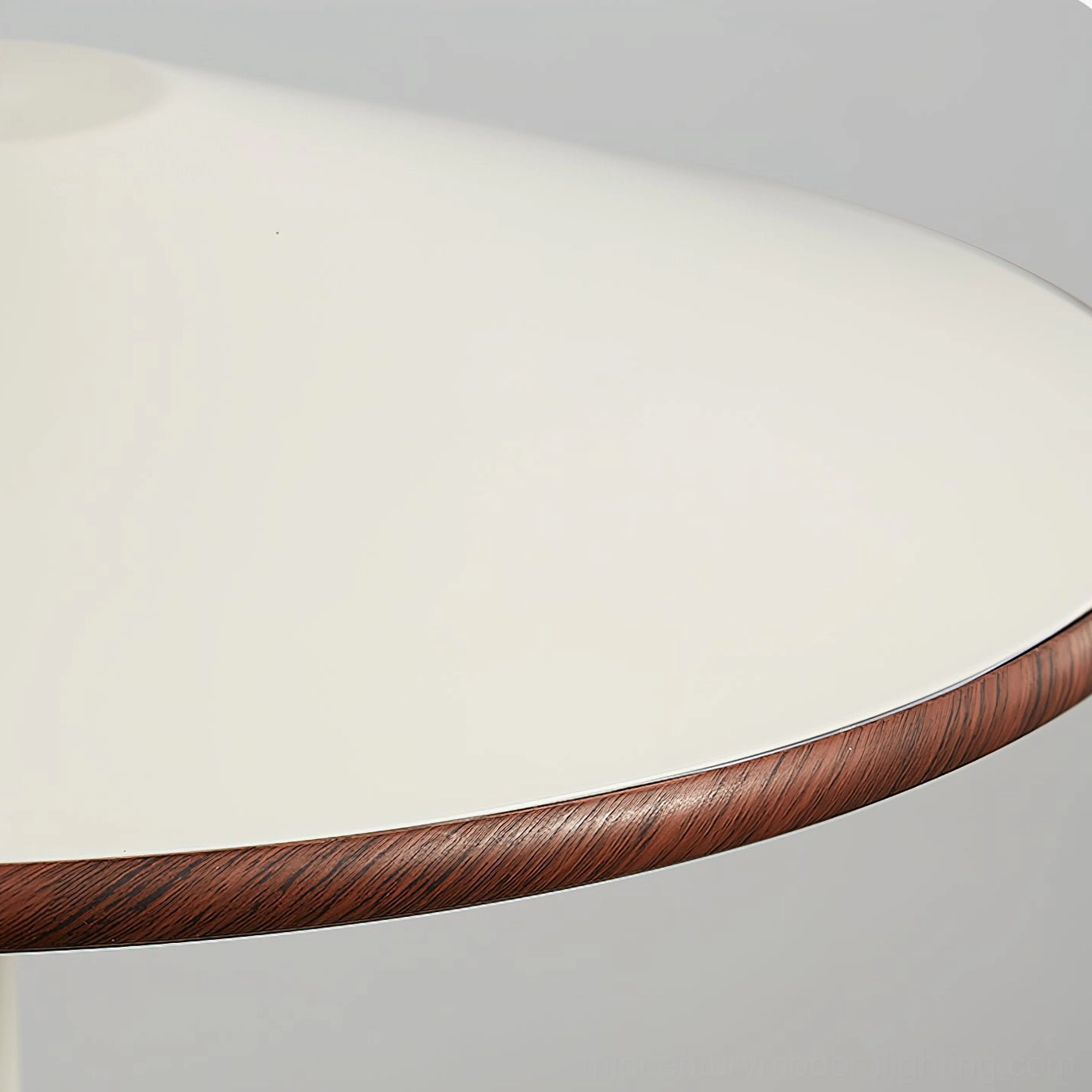 Detailed side view of Remy lampshade highlighting walnut wood trim and matte off-white cream metal shade on gray background