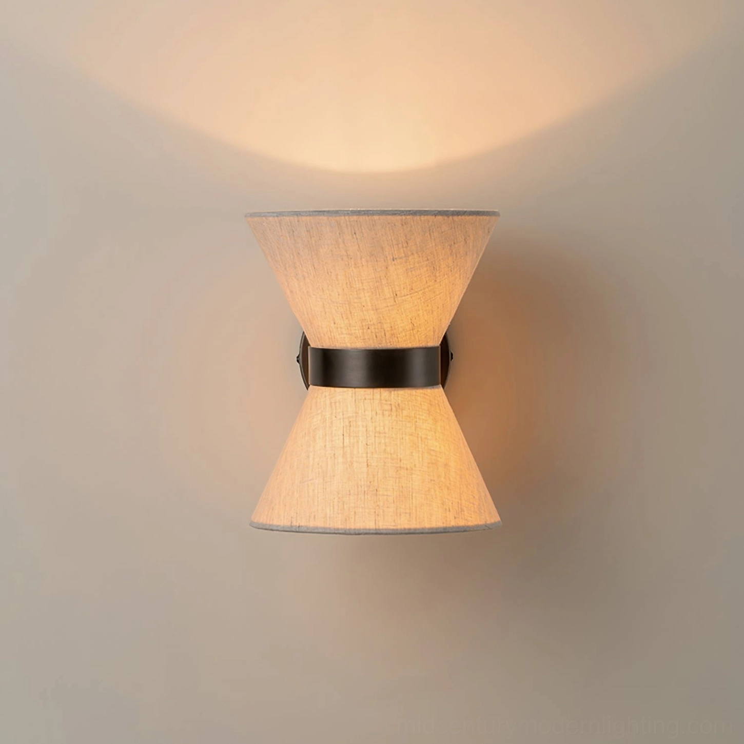 Lit Renwick hourglass wall sconce on white wall showing dual light distribution and symmetrical design