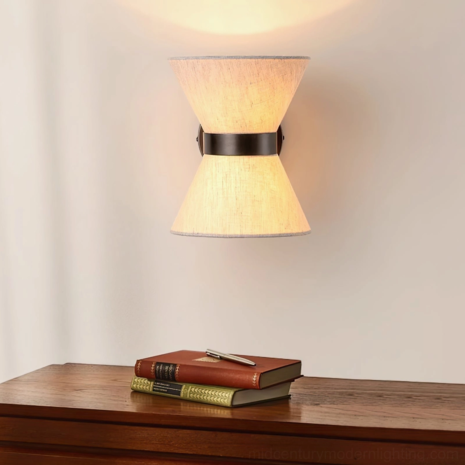 Renwick wall light mounted above wooden vanity table in rustic bedroom, soft glow illumination