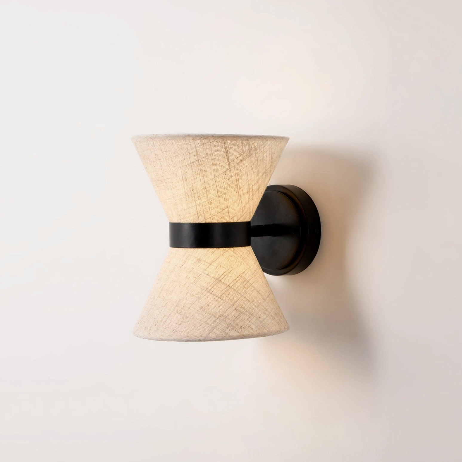 Close-up detail of Renwick wall sconce showing textured linen fabric weave and black metal accent band