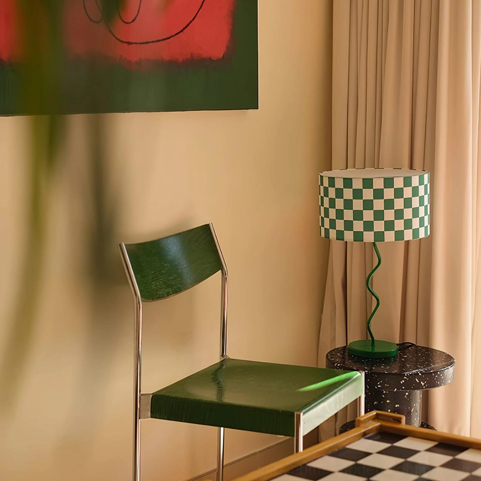 Mid-century style chessboard lamp beside green leather chair with wall art and curtains