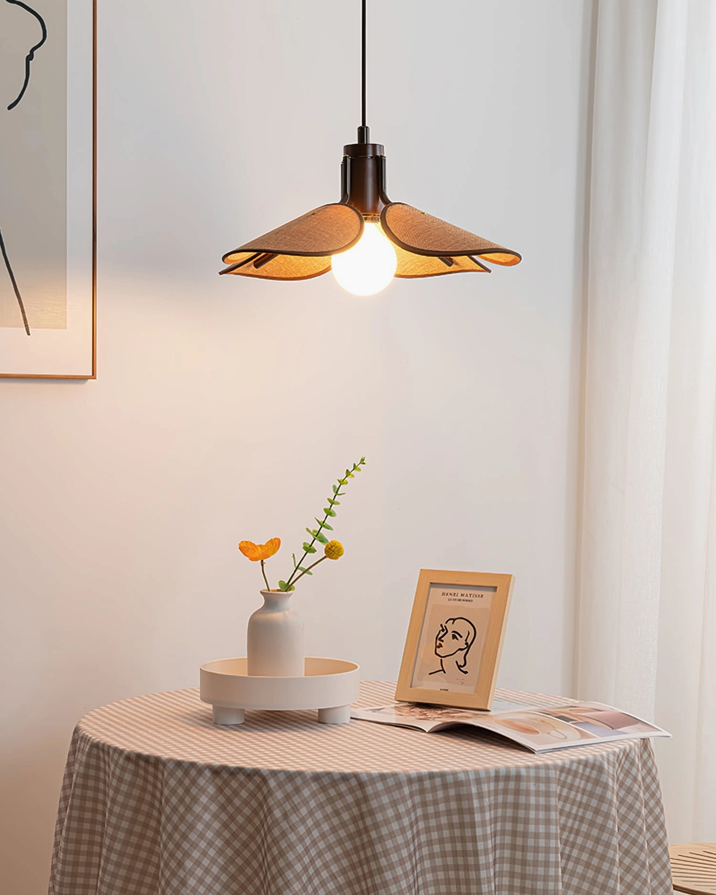 Riankh pendant light mounted at eye level in minimalist living space with wall art, showing warm yellow lighting ambiance