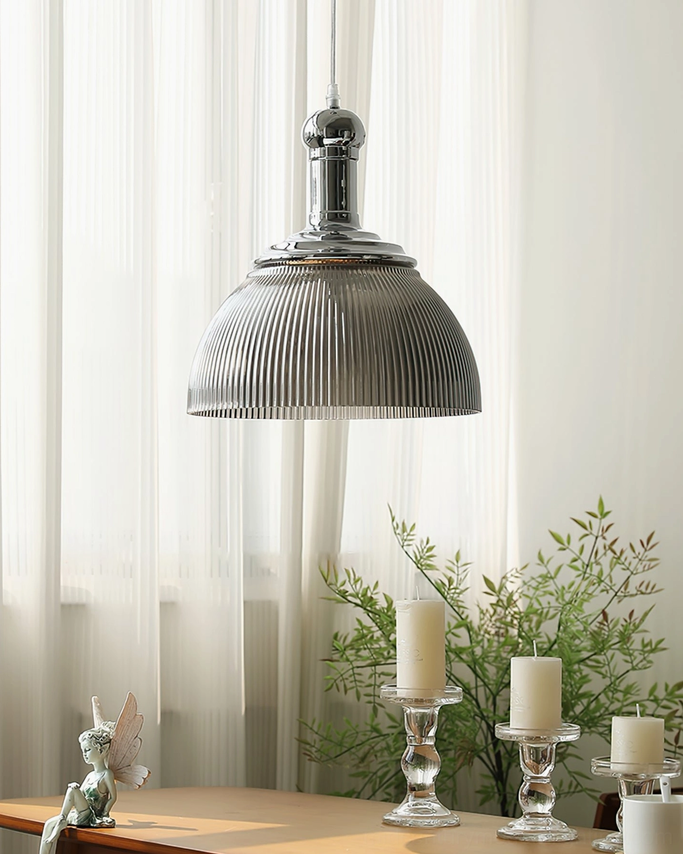 Ribbed chrome pendant lamp installed above dining table in elegant interior setting, side angle view