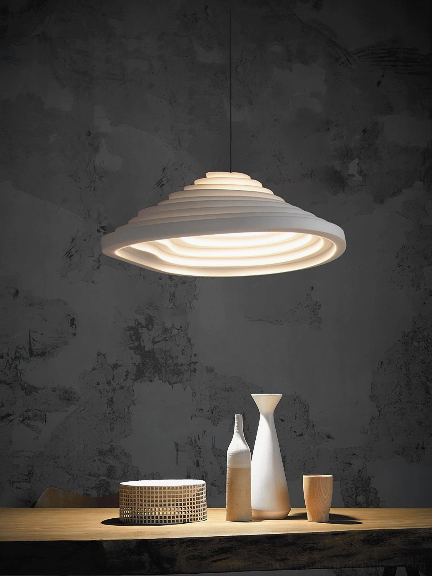 Rice Field Acoustic Tapered Pendant illuminated against dark accent wall - warm glowing minimalist ribbed pendant design