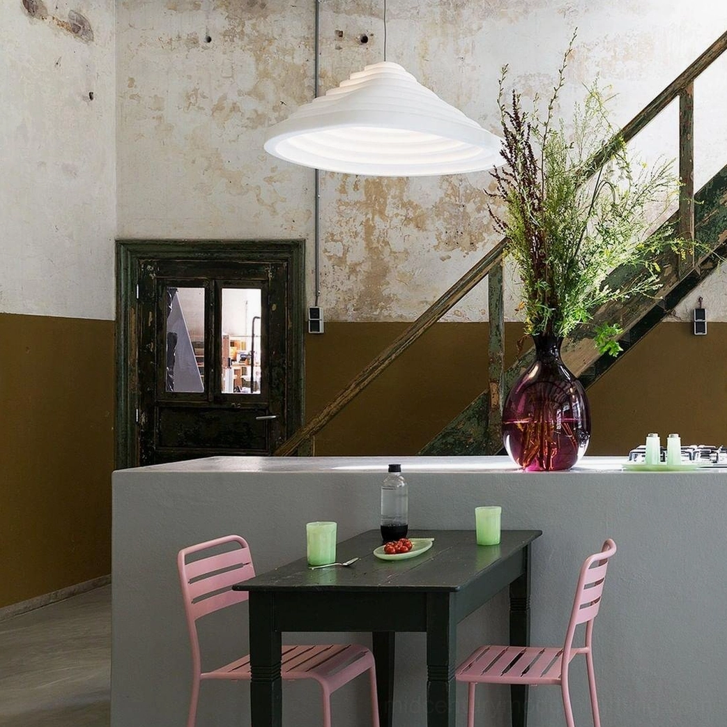 White matte acoustic tapered pendant lamp in vintage industrial dining corner with rustic textured finishes