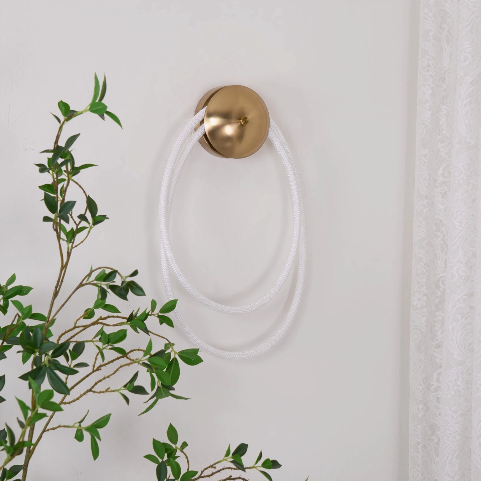 Rigel wall sconce artistic rope lighting in contemporary interior with green foliage styling