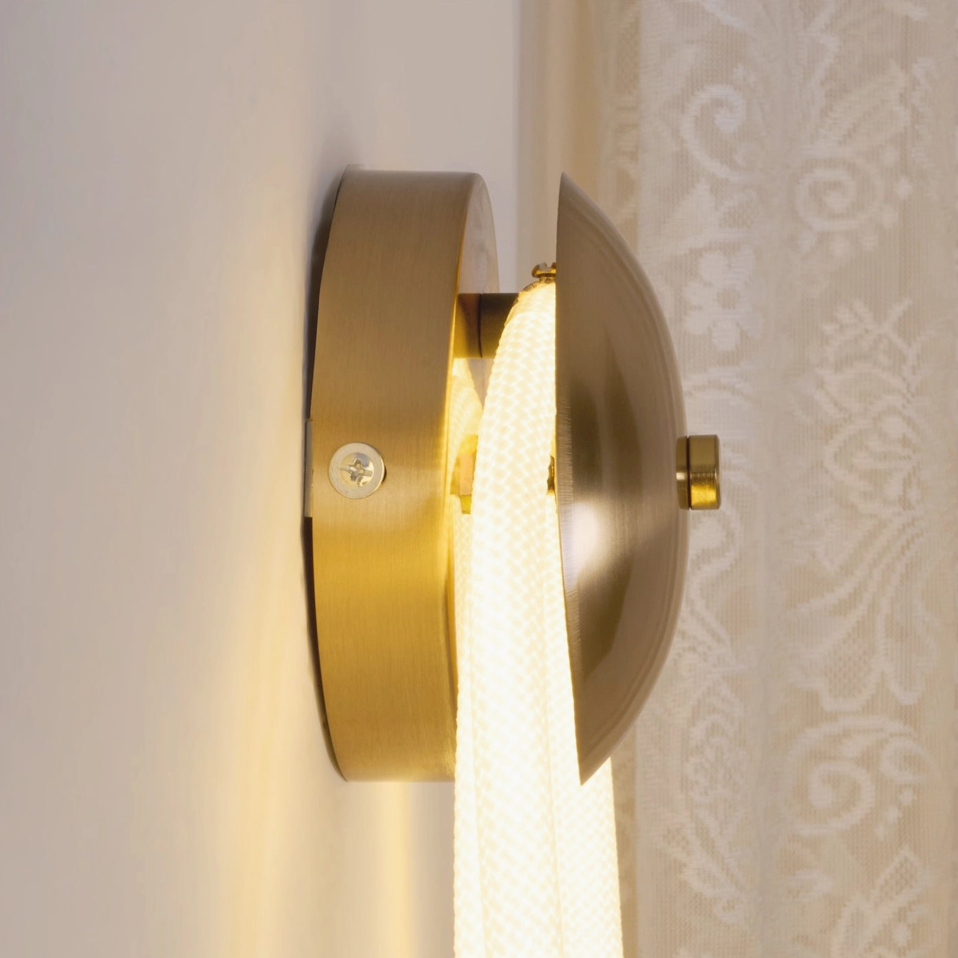 Rigel wall lamp side close-up showing brushed brass metal base white woven rope and mounting system