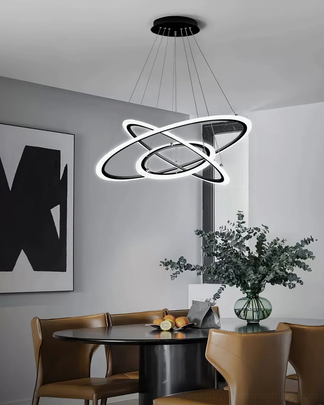 Modern three-tier ring chandelier illuminated above round dining table in contemporary neutral dining room setting