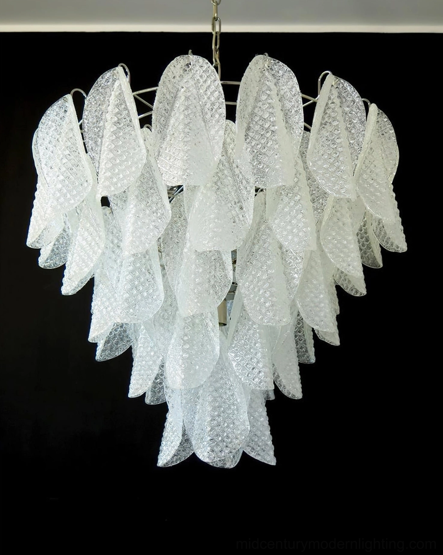 Ripple glass chandelier suspended in elegant dining space demonstrating scale and proportional placement