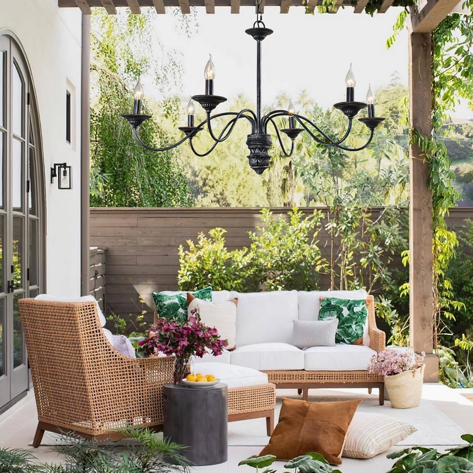 Rohan 6-light black outdoor chandelier installed on covered patio backyard tropical lounge area decor