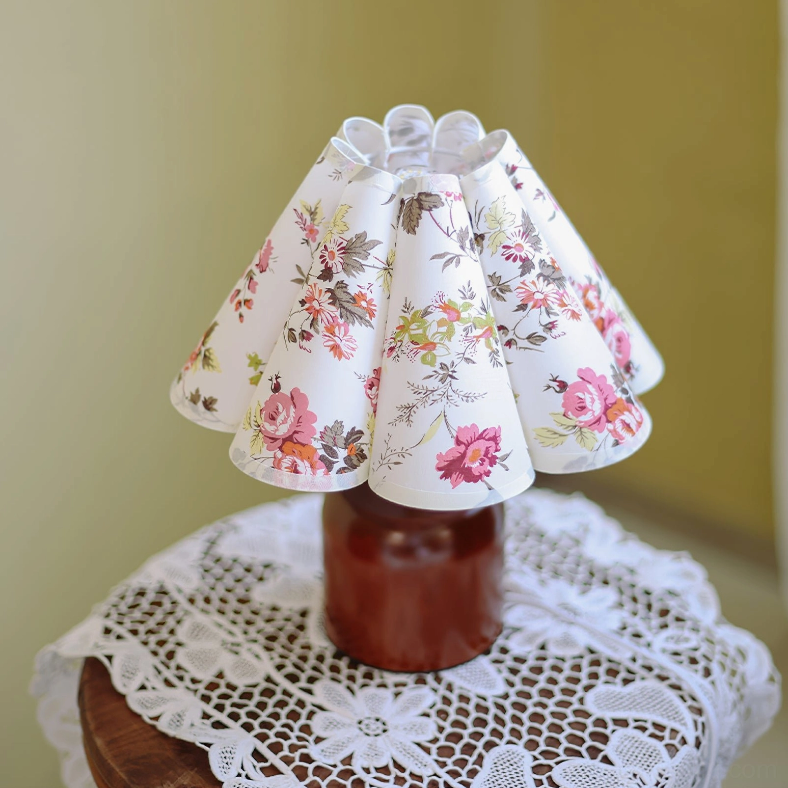 Side view of vintage floral table lamp showing pleated fabric shade with dark pink rose print