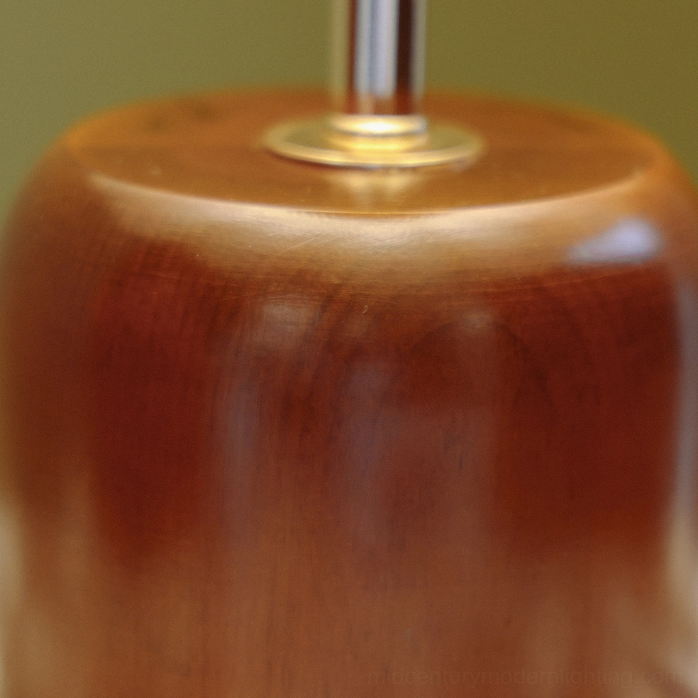 Close-up detail of wooden lamp base and brass metal mounting ring, solid walnut construction