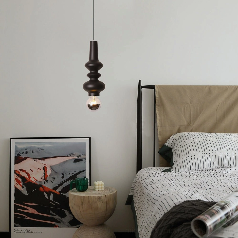 Rudd matte black pendant light with stacked cylinders and exposed bulb in modern bedroom with beige headboard