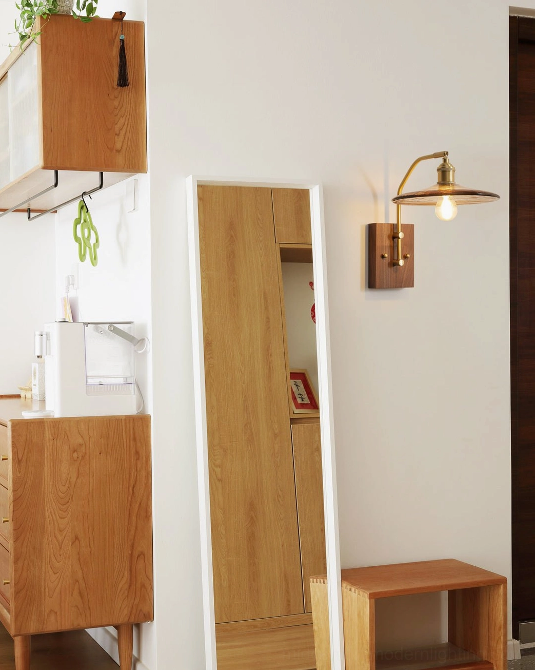 Runia compact wall sconce in small apartment entryway showing consistent brass and walnut retro design from distance