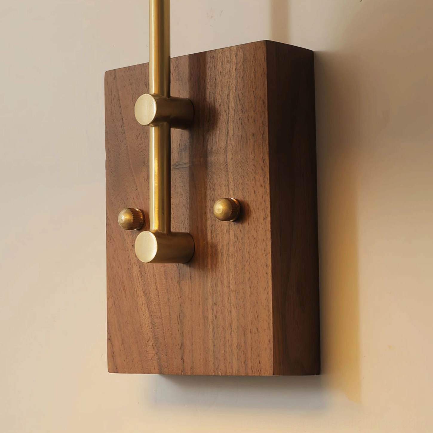 Runia wall lamp mounting hardware close-up showing solid walnut plate, brass knobs, and metal support rod assembly