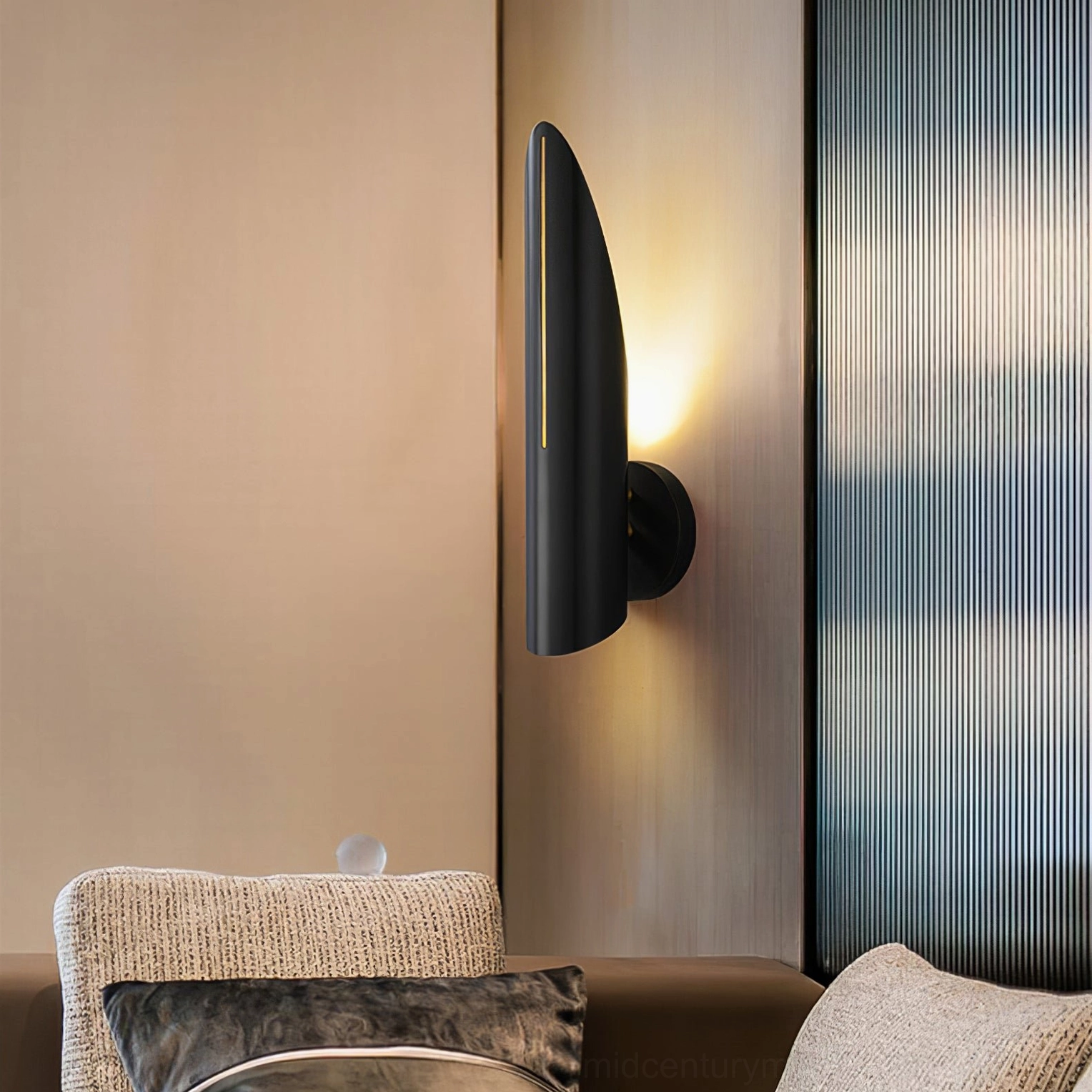 Single Salvatore matte black wall sconce in modern living room with sofa understated accent lighting