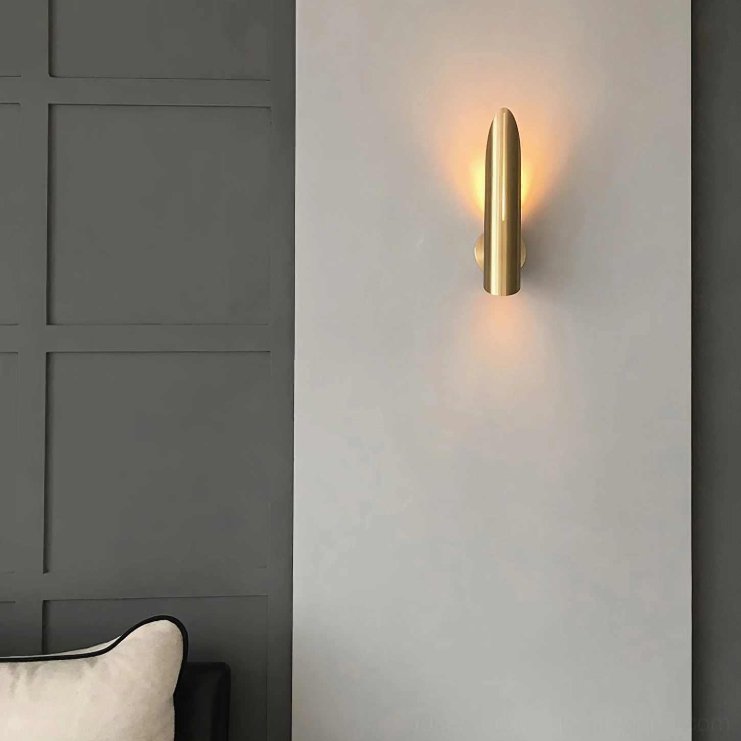 Salvatore brass wall sconce mounted on bedroom paneled wall with bedding mid-century modern accent lighting