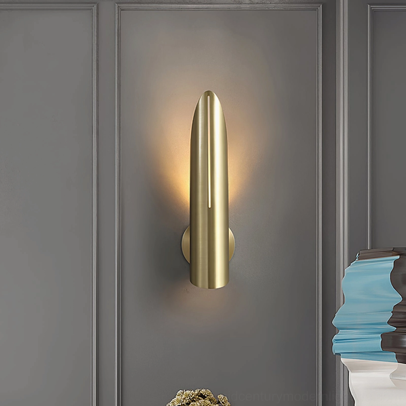 Salvatore brass bullet wall sconce on paneled indoor wall luxury minimalist modern lighting fixture