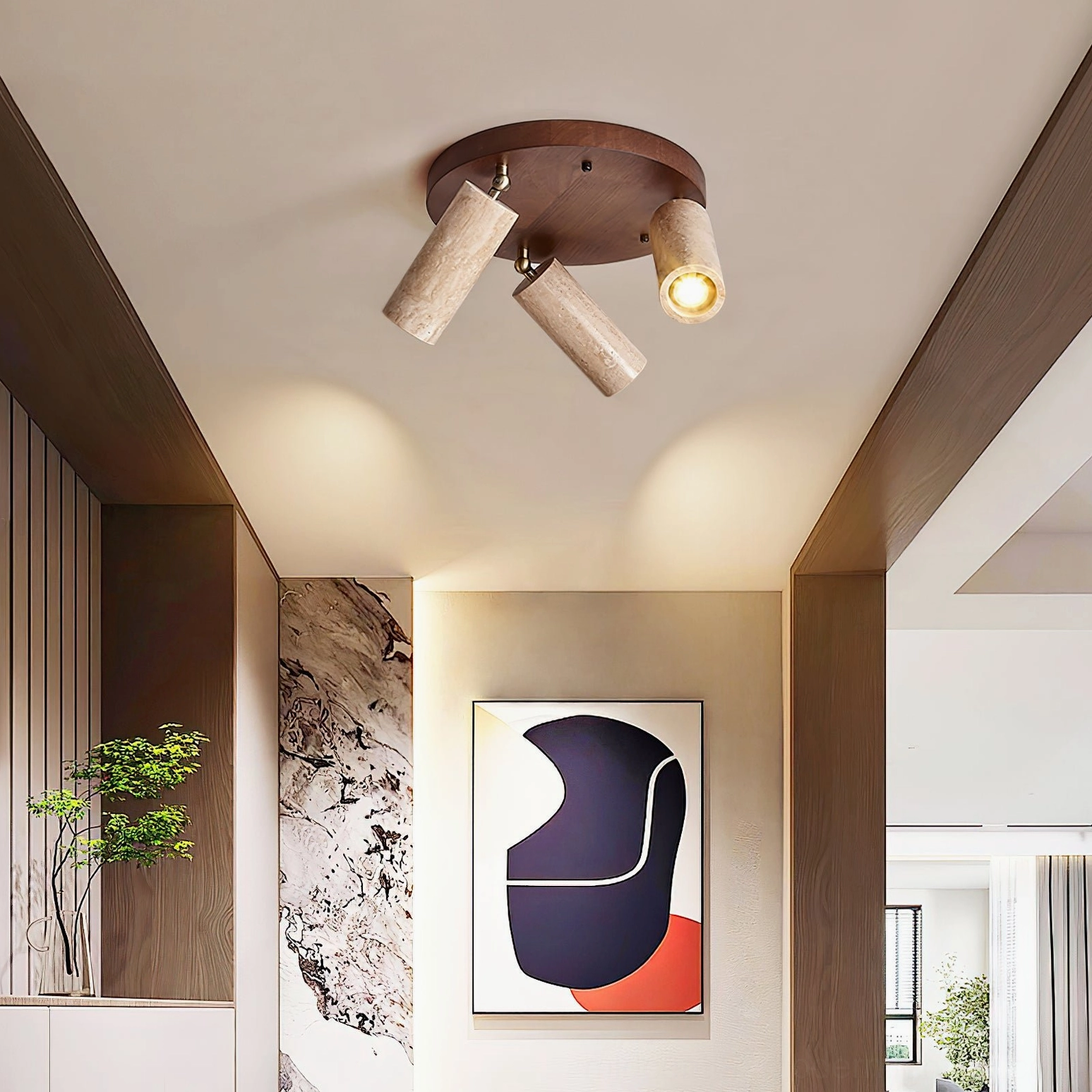 Sandia 3-head ceiling spotlight with dark wood base and adjustable travertine heads in residential hallway with abstract art