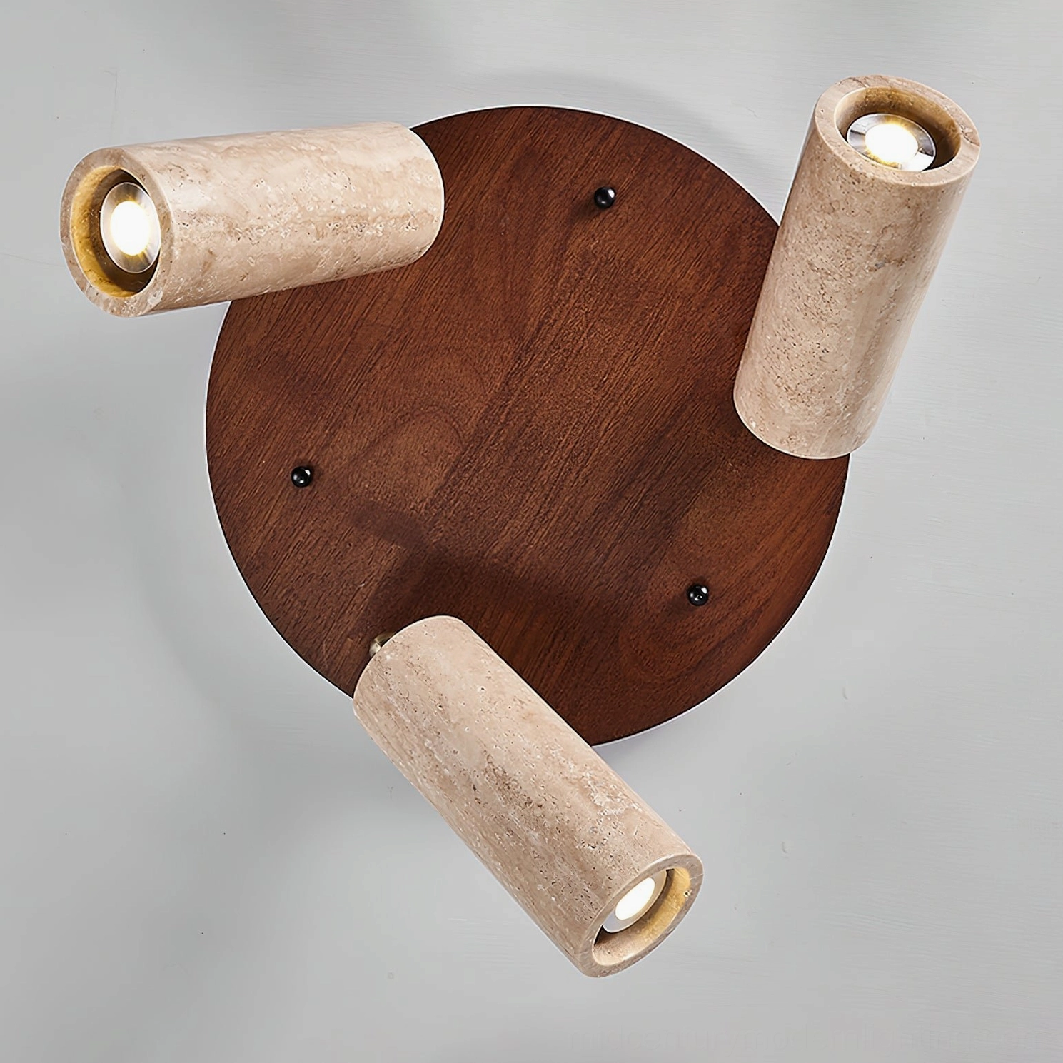 Overhead close-up view of Sandia ceiling spotlight base showing dark walnut round base with three travertine lamp tubes