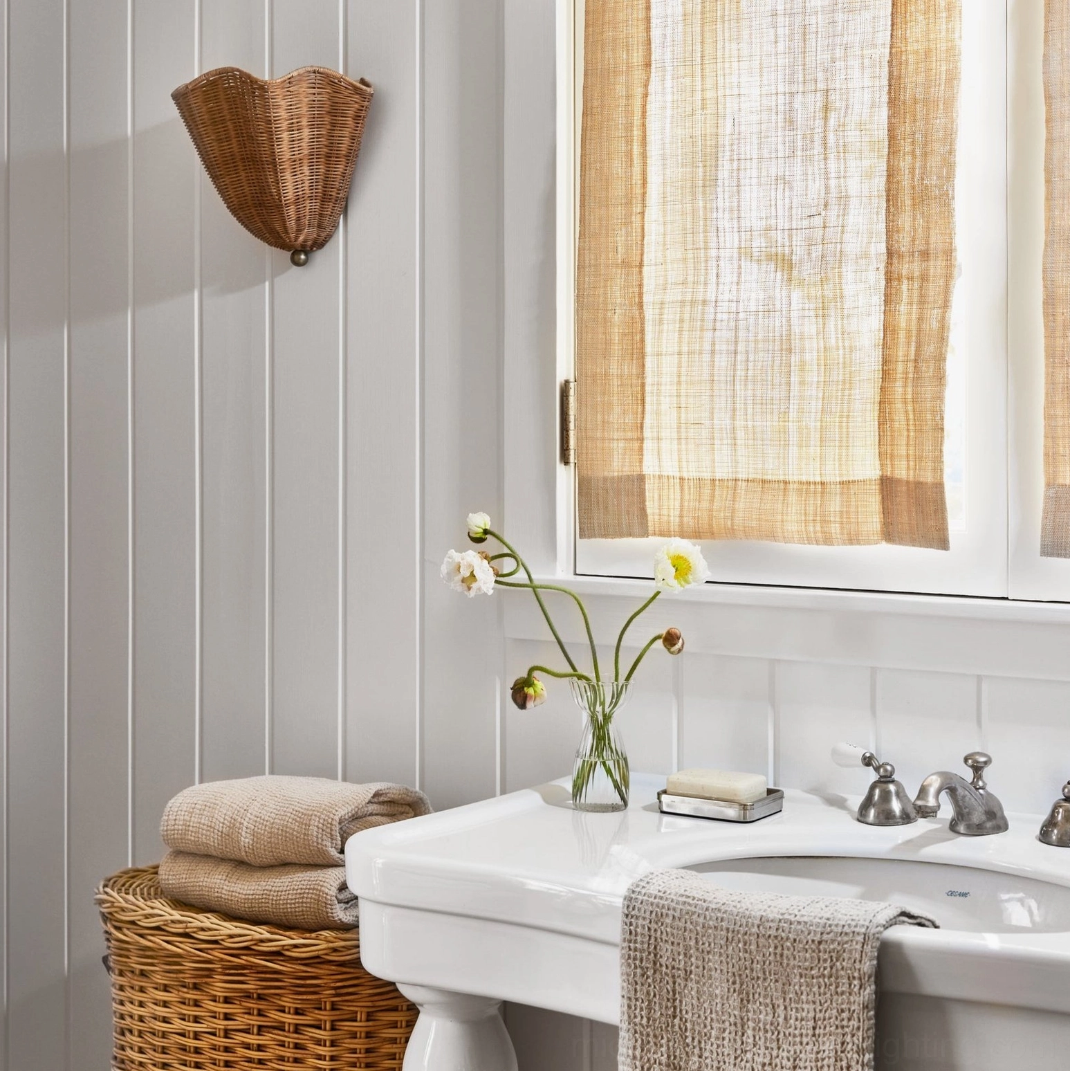 Sarasota rattan wall sconce in small bathroom vanity setup, boho coastal bathroom lighting design