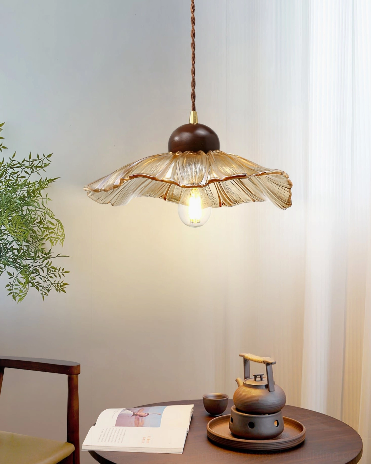 Scalloped floral pendant lamp above casual dining round table warm wood tones