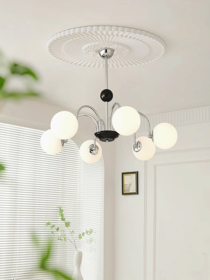 Globe pendant chandelier with ceiling canopy mounted in minimalist white residential space