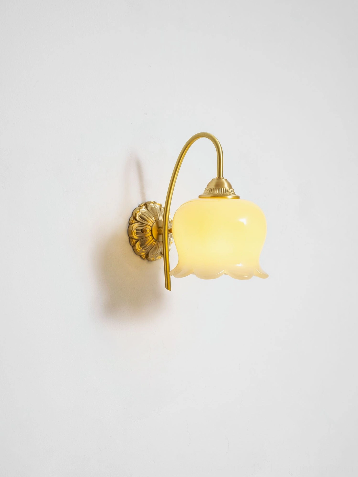 Brass and cream lily of the valley wall sconce in scandinavian-inspired minimalist room decor