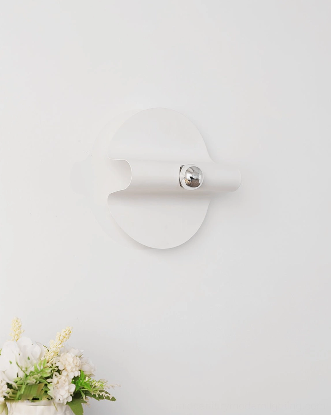 Modern minimalist wall lamp with matte white finish and chrome fixture on neutral wall