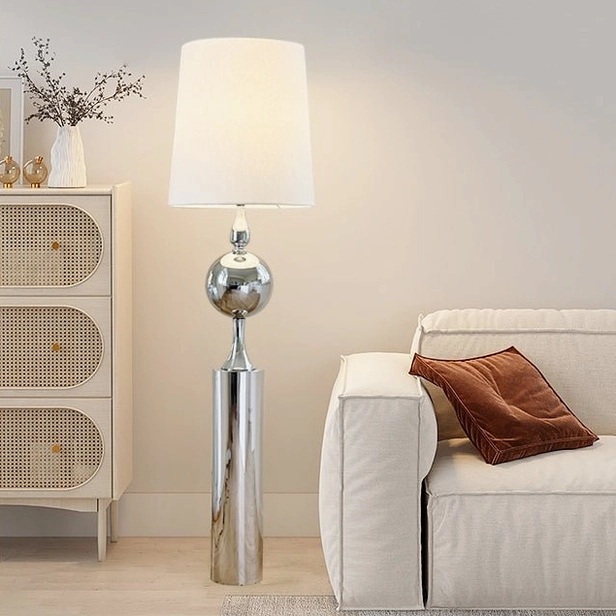 Full-length view of sculptural chrome floor lamp showing complete silhouette with fabric shade and adjustable joint design