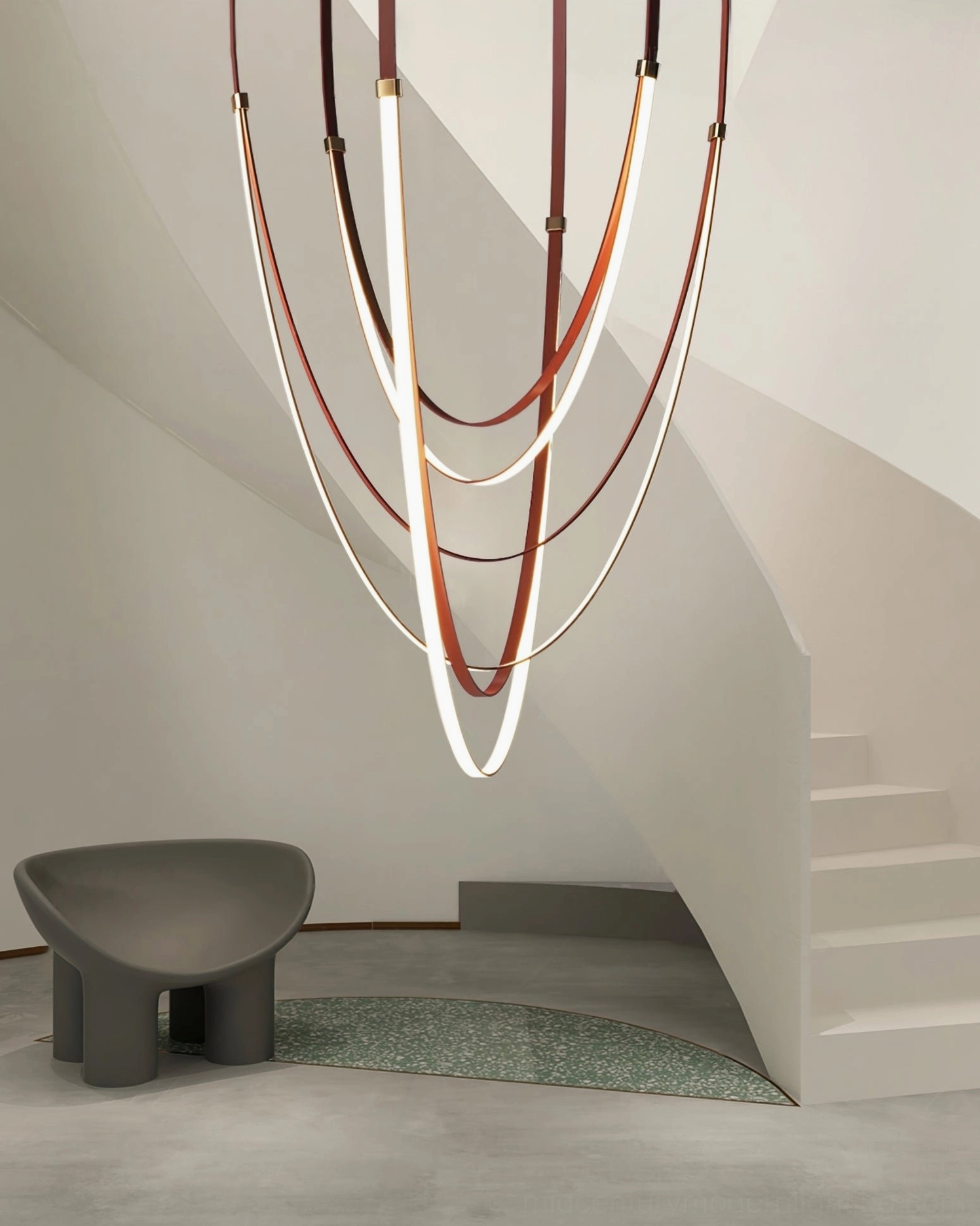 Modern sculptural pendant chandelier with sleek leather and metal finish suspended in minimalist duplex space
