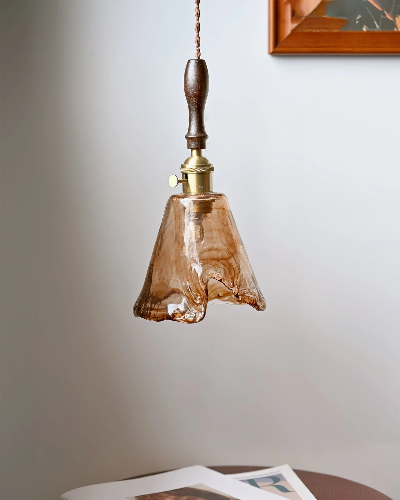 Organic sculptural pendant lamp with warm amber light in eclectic interior design setting