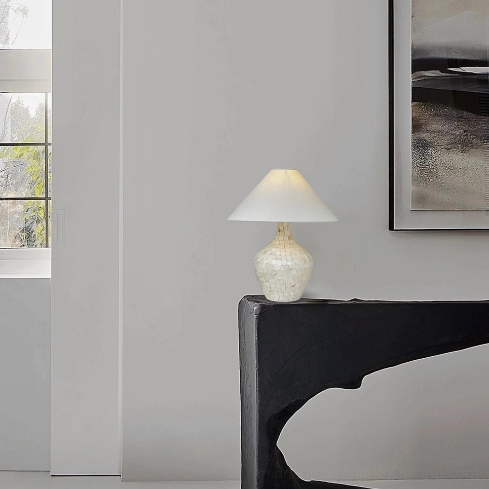 Compact seashell mosaic lamp on curved black console table against minimalist wall, contemporary entryway styling