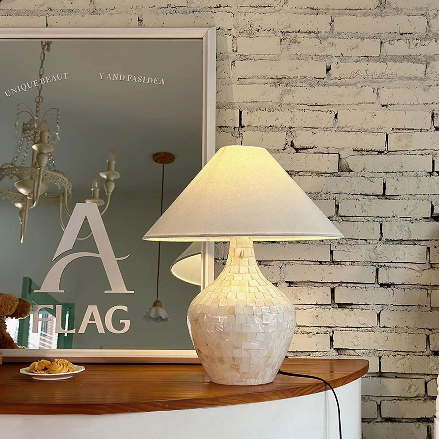 Mosaic seashell lamp on brick wall countertop with decorative mirror and dessert plate, kitchen accent lighting