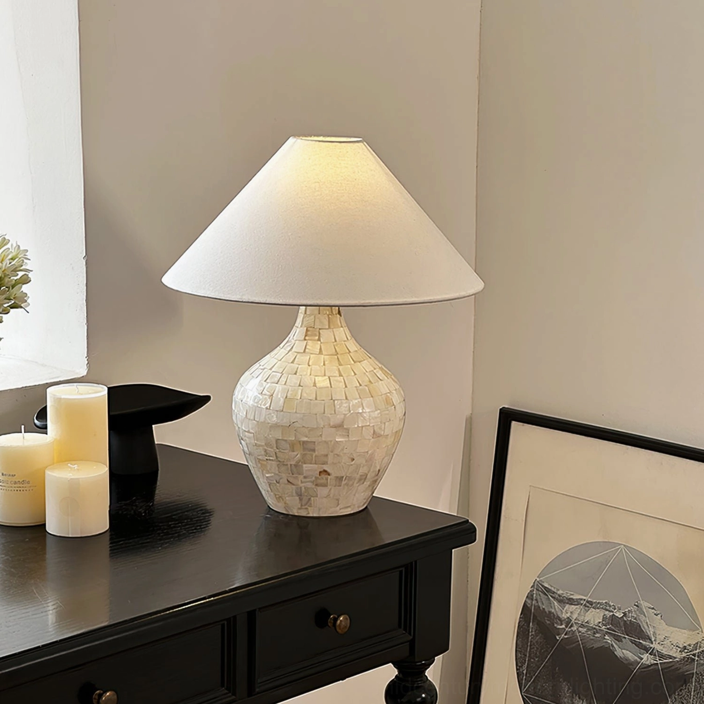 Handcrafted seashell table lamp on dark wooden dresser with candle set and wall art, elegant bedroom corner styling