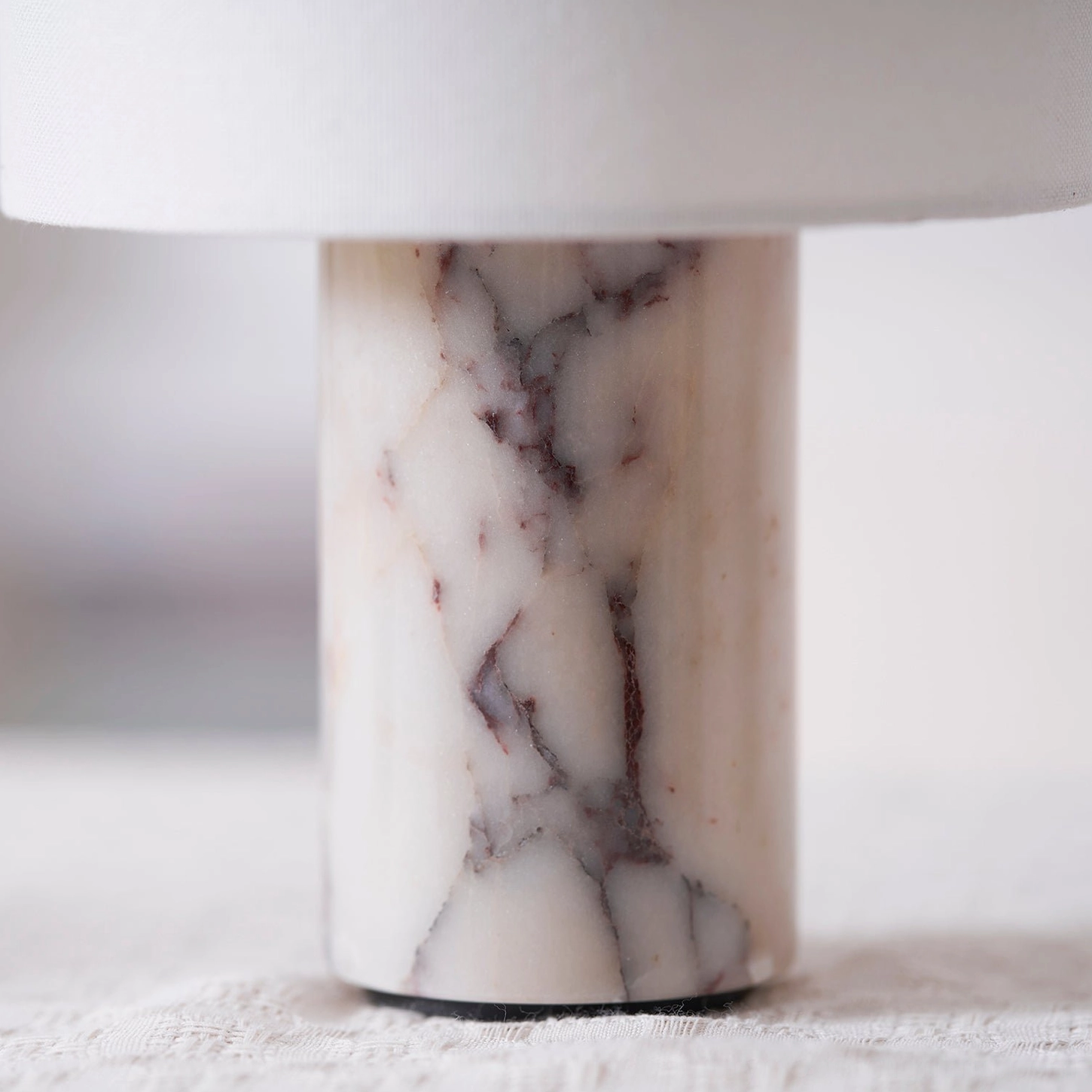 Sediment marble table lamp lit in evening ambient setting with warm diffused glow