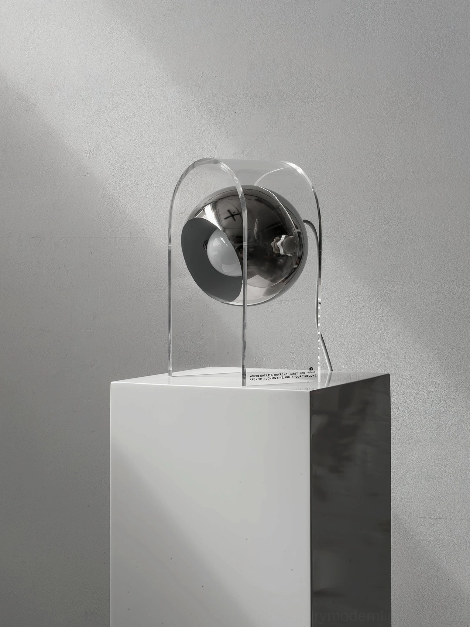 Unlit modern touch table lamp on white pedestal display with minimalist monochromatic styling