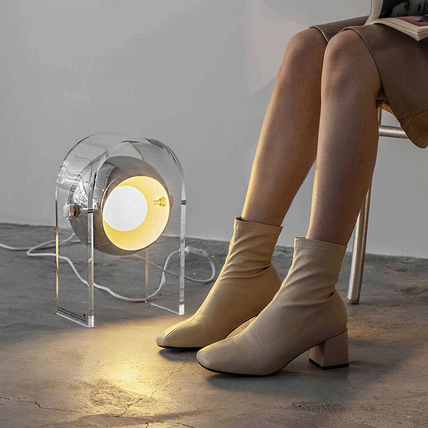 Touch table lamp emitting warm ambient light in modern home interior with concrete flooring