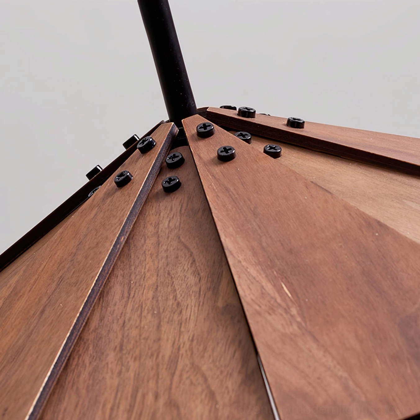 Close-up detail of sepal pendant lamp wooden joinery showing black hardware and walnut wood construction