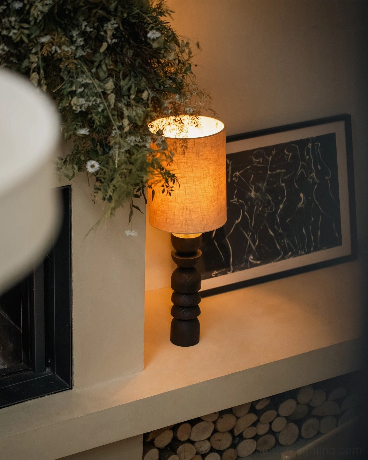 Sergio sculptural wood lamp styled on fireplace side table with green plants and wall art