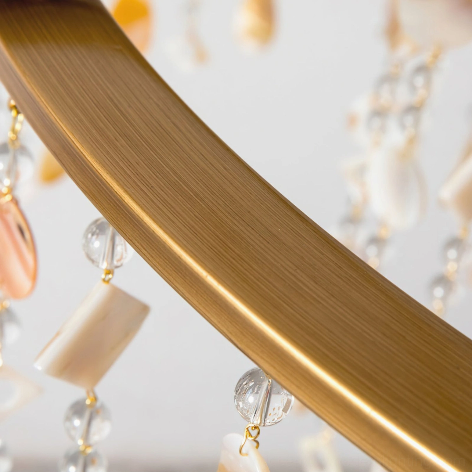 Shell Elegance Chandelier low-angle close-up of brushed brass frame structure and glass bead shell pendant decorations