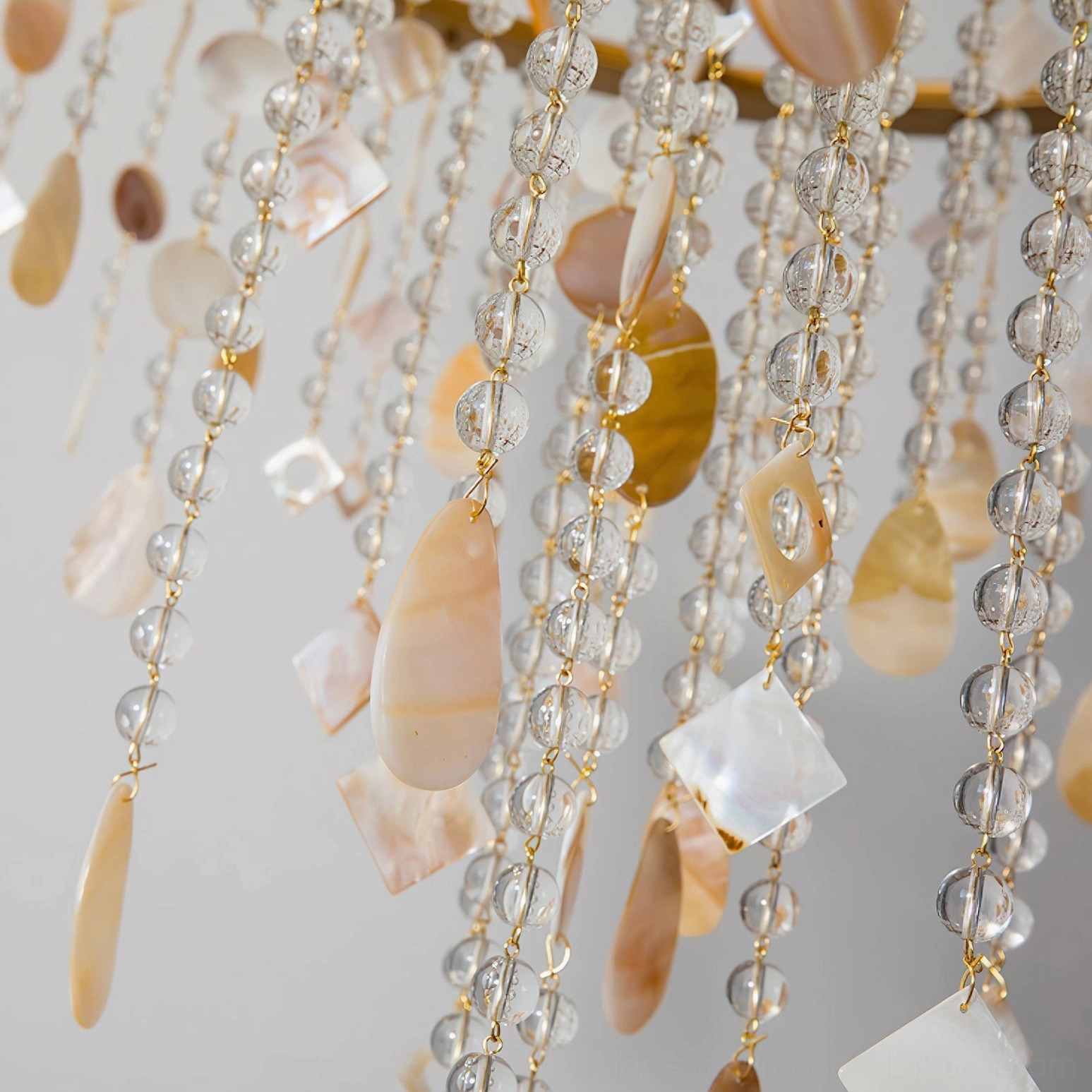 Overhead view of Shell Elegance Chandelier decorative strands featuring mixed glass crystals and natural shell pendants in warm gold tones