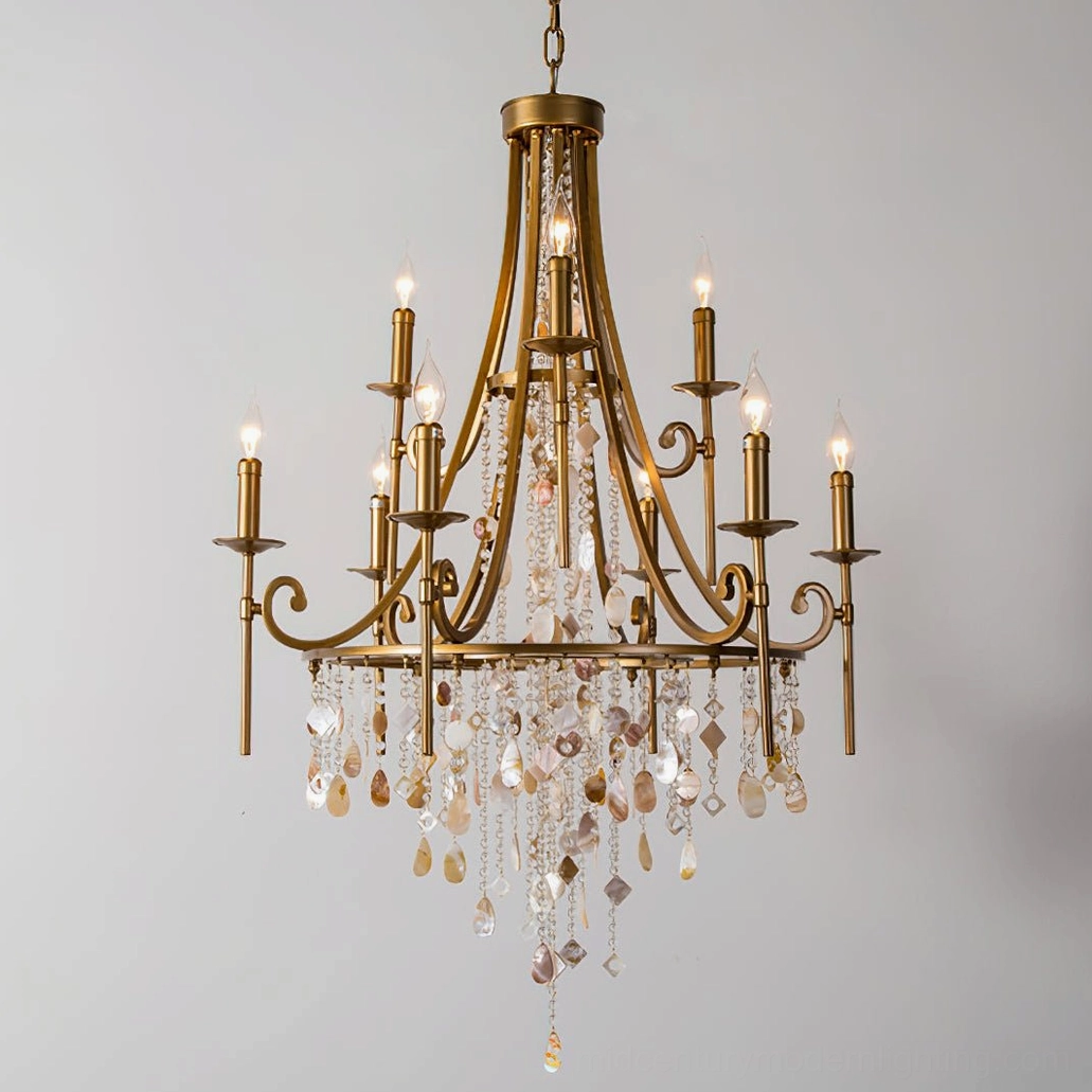 Luxury brass chandelier close-up detail of curved candle arms with dangling crystal beads and natural shell accents