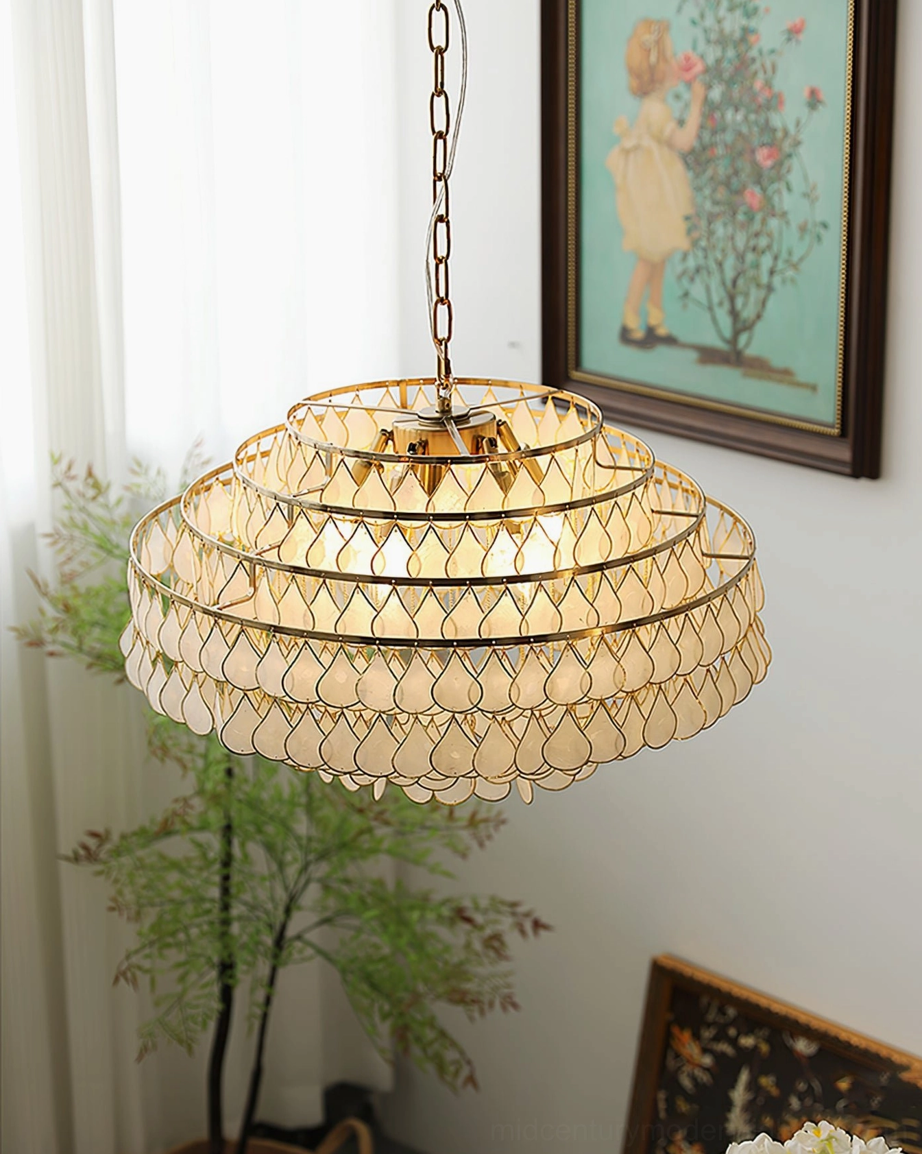 Tiered shell pendant lamp bottom-up three-quarter view, bright home corner with framed art, potted plant and floral decor, elegant French luxury