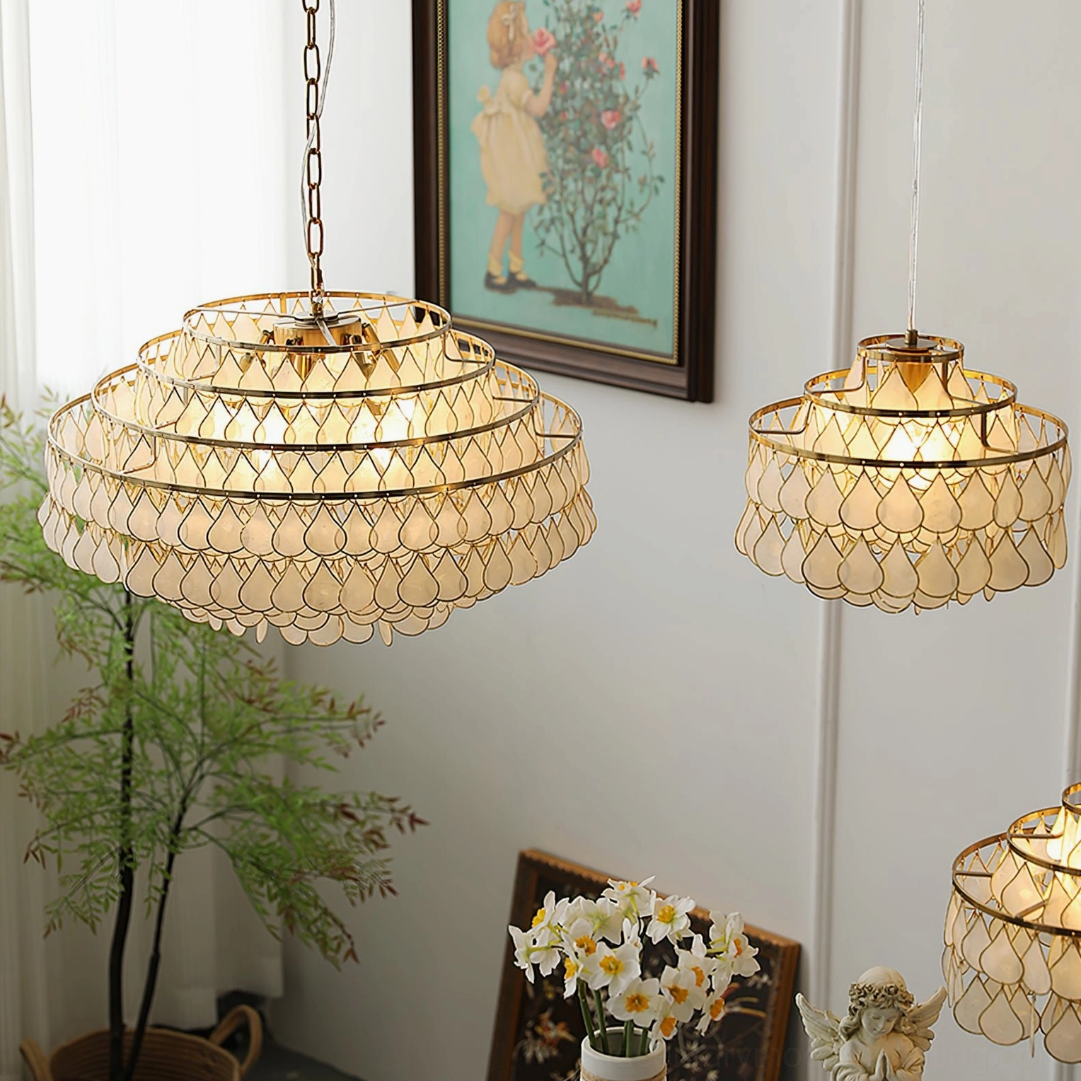 Shell pendant lamps in different sizes displayed, three-quarter view with retro home wall corner, framed art, potted plants, French vintage design
