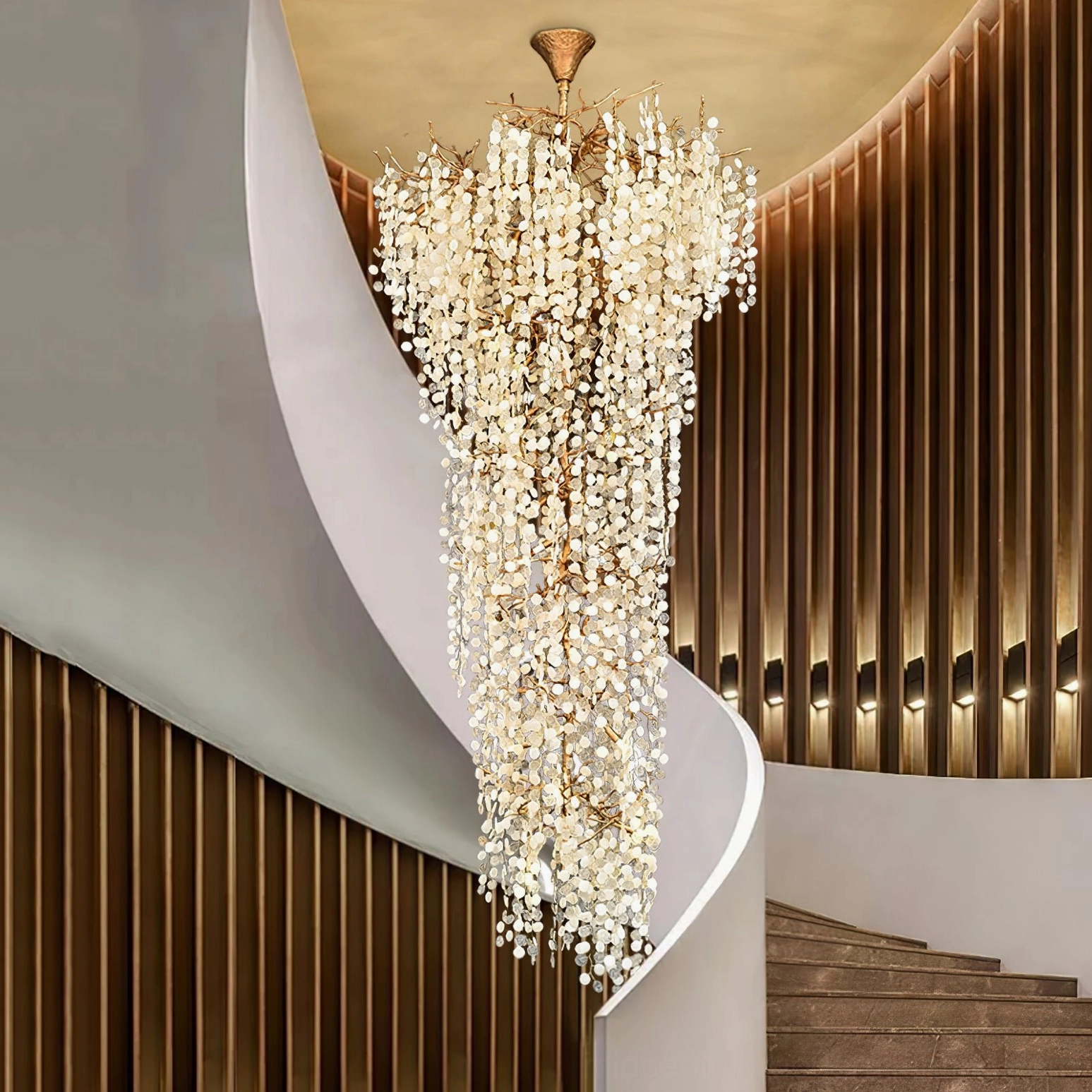 Shiro Noda cascading crystal chandelier in spiral staircase luxury foyer with brass-paneled walls