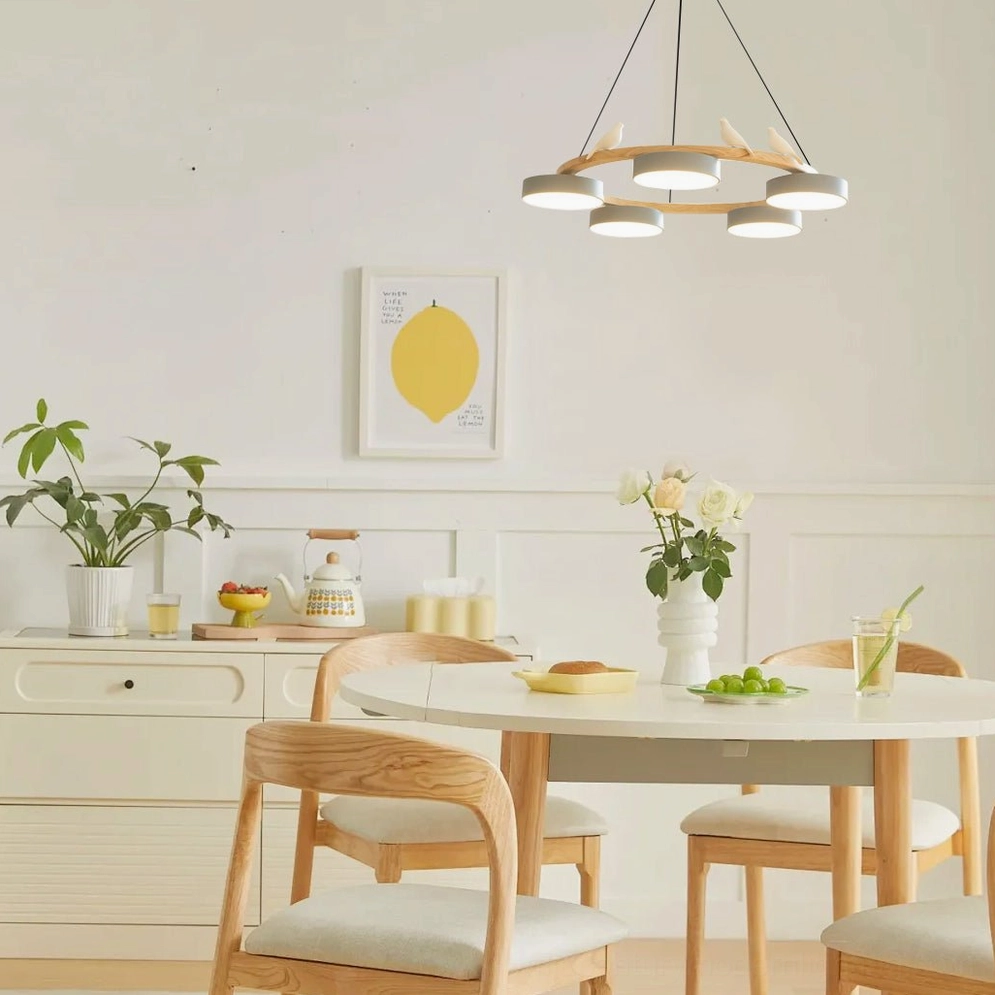 Sienna bird round pendant chandelier suspended in modern Nordic dining room above wooden table, white lamp shades with warm ambient lighting