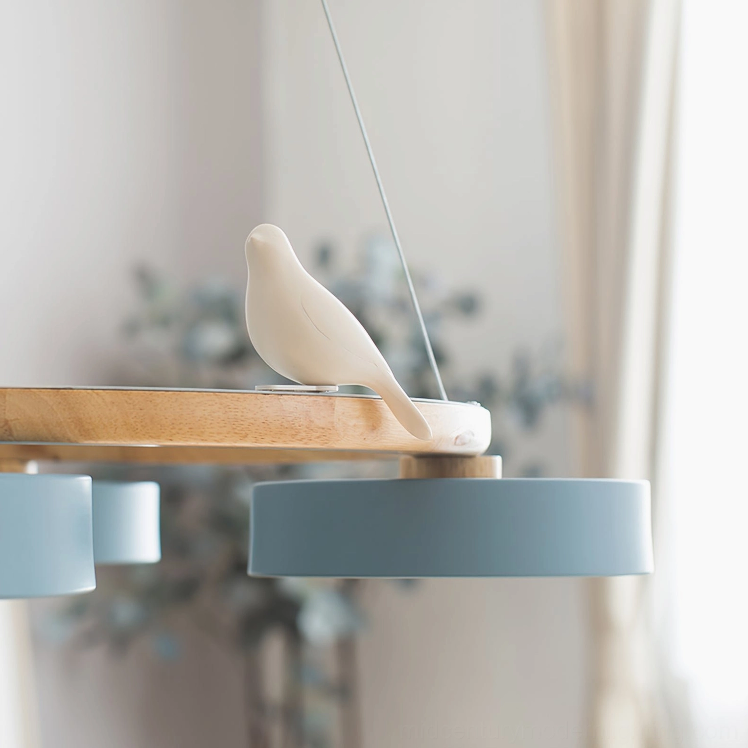 Sienna bird round pendant chandelier with gray-blue lamp shade and white ceramic bird perched on wood frame, soft natural daylight interior
